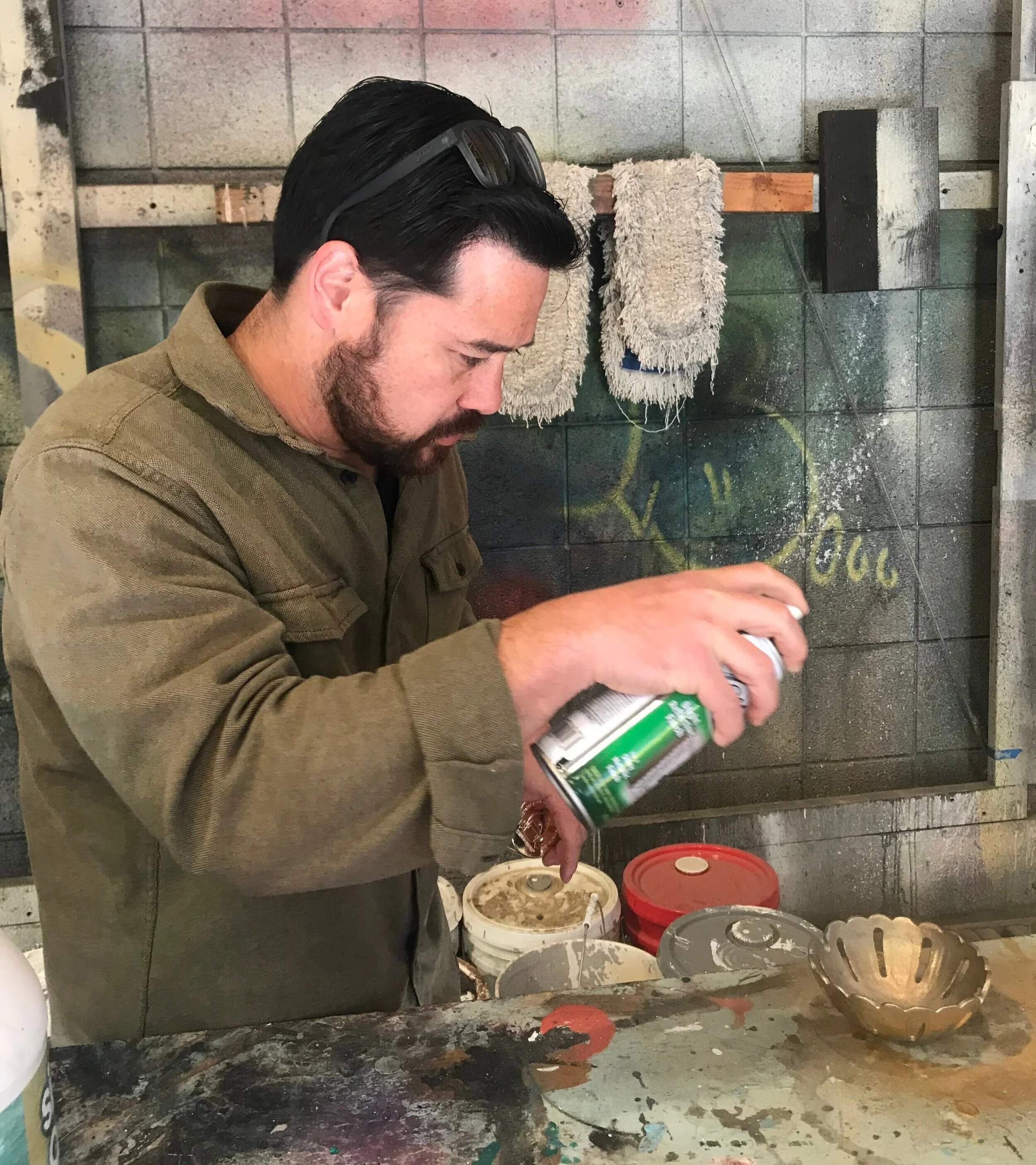  Outgoing technical director Jamie Birkett spray-painting a prop for the upcoming production of  Tartuffe.  