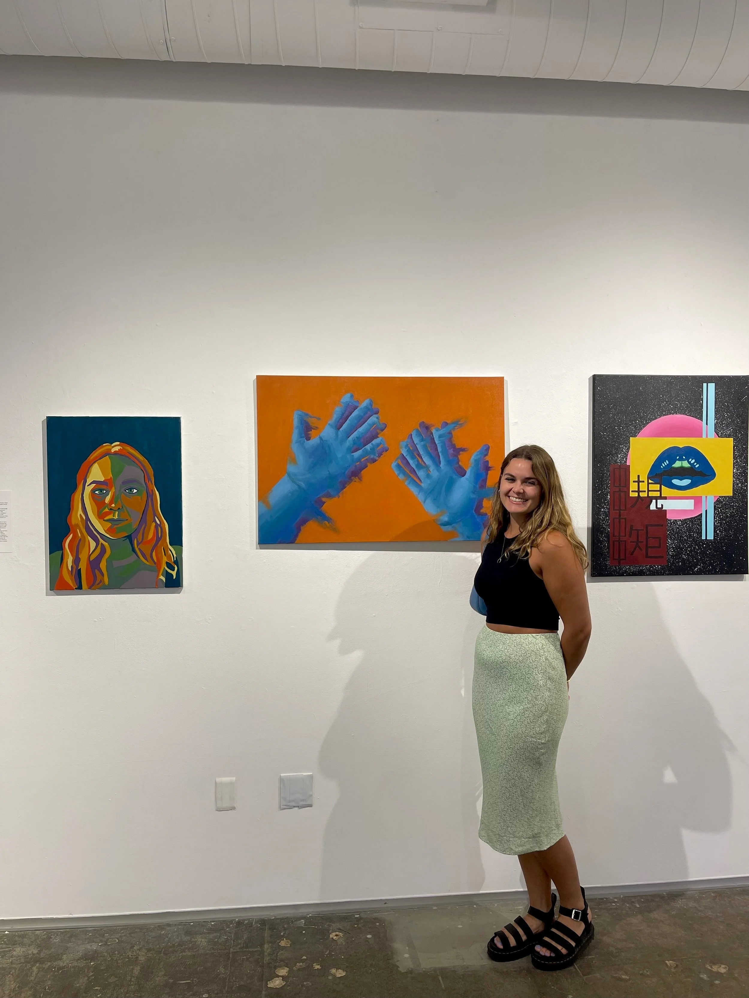  Student artist Elena Aquilanti, to the right of her two paintings. 
