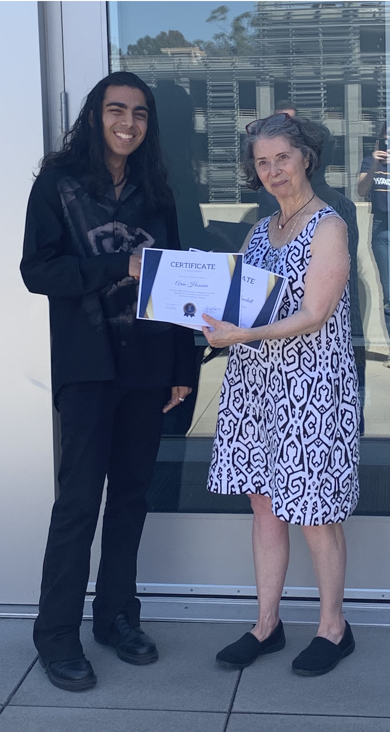  At a lunch event, the runner-up in the poetry category for the HFA creativity contest, Aran Hosseini, accepted his award from the Acting Dean of Humanities and Fine Arts, Mary Hancock. 
