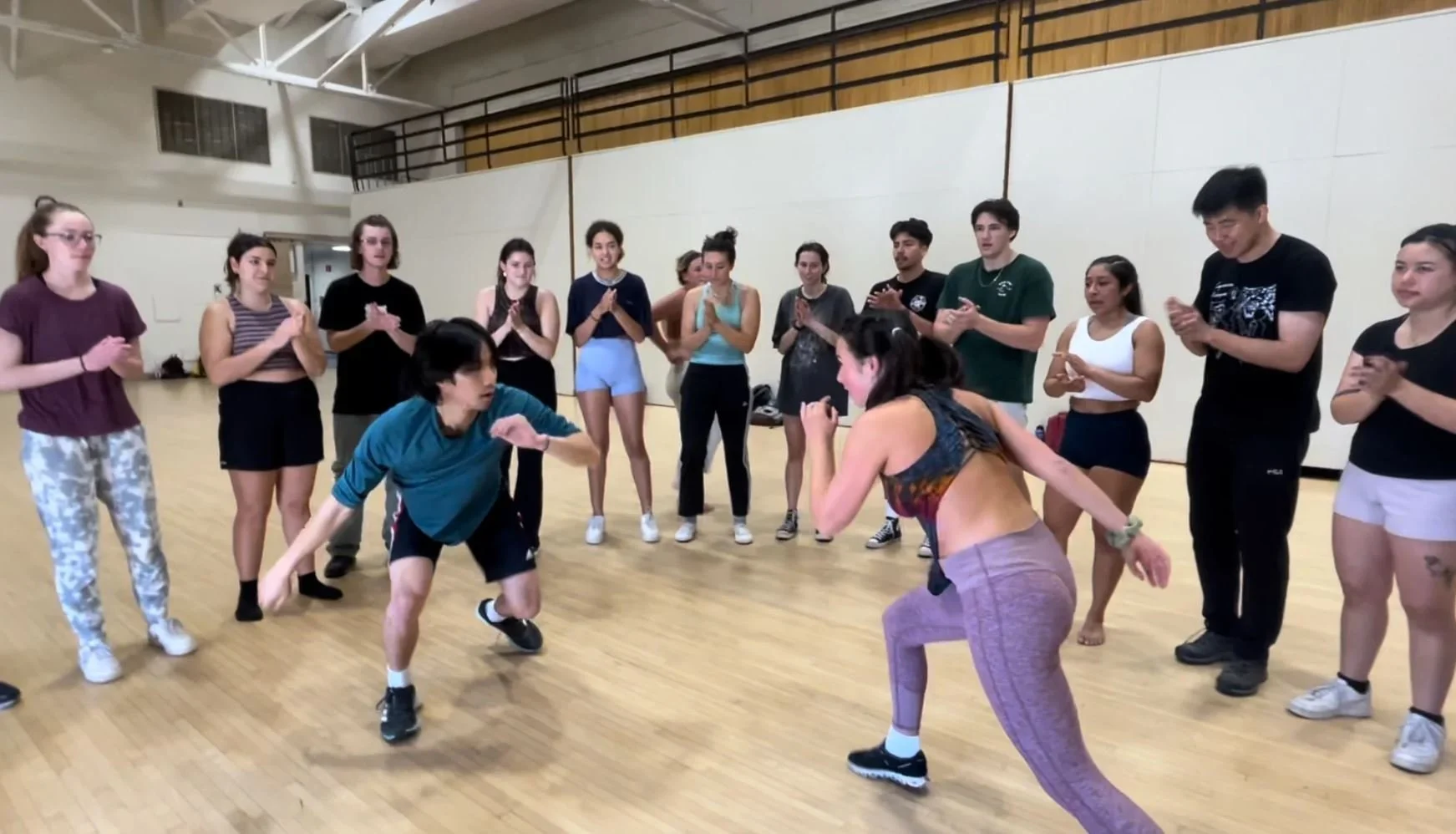  Students enrolled in Mariano Silva’s capoeira class gradually progress towards participating in a  roda , a circle where two individuals play against each other and show off their creative development in the art.  